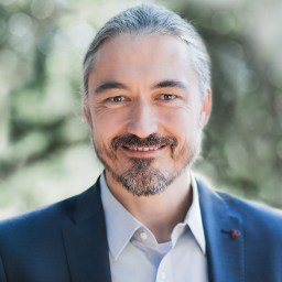 A man in a suit smiles for the camera.