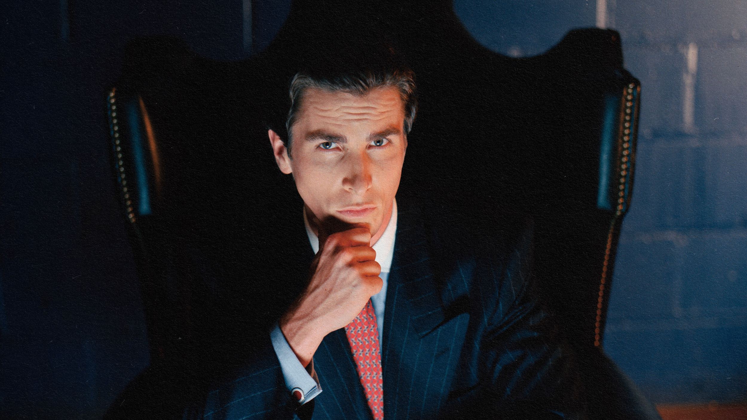 An alpha male in a suit sitting in a chair.