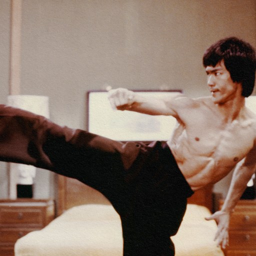 Bruce Lee executing a pain-free kick in a bedroom.