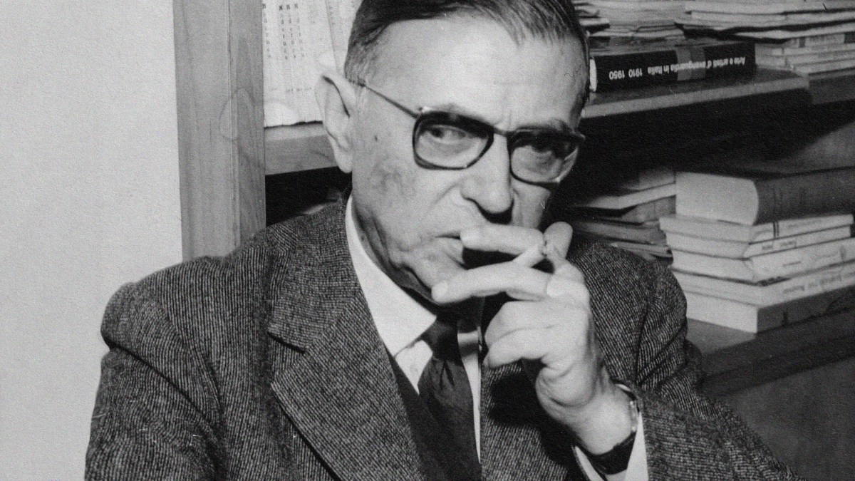 An old black and white photo showing a man smoking a cigarette.