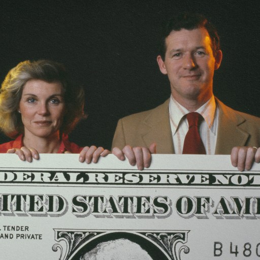 A couple displaying a generous federal reserve note.