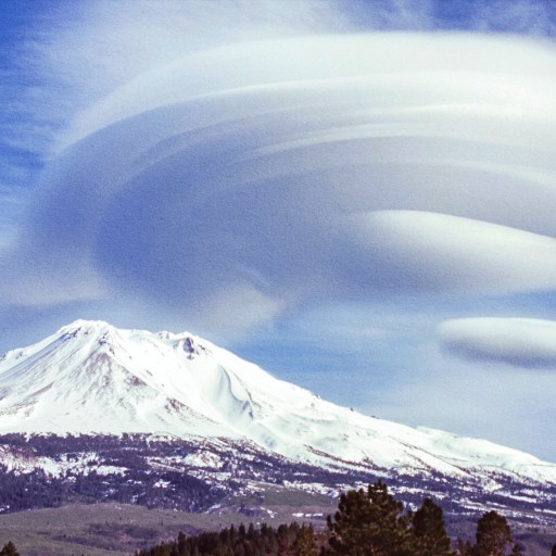 A cloud over Mount Shasta with a mountain in the background.