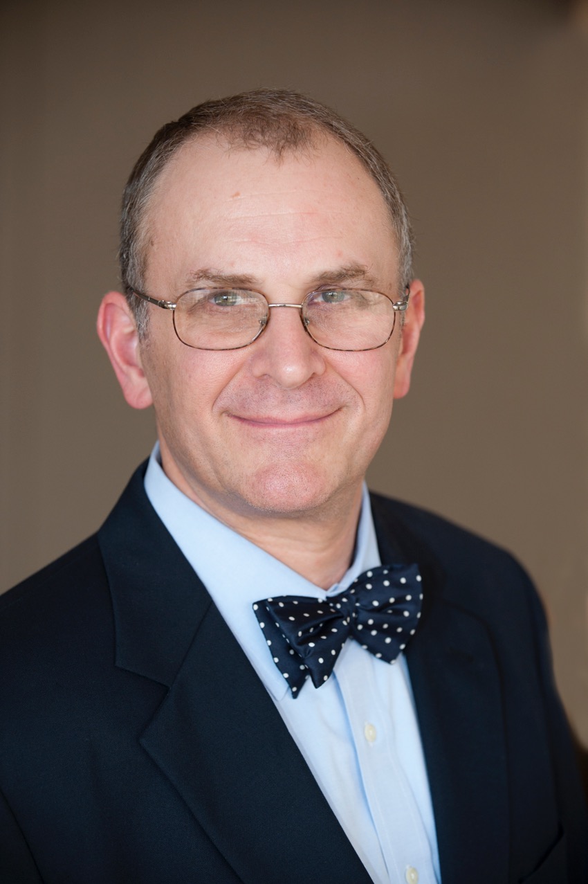 A man wearing glasses and a bow tie.