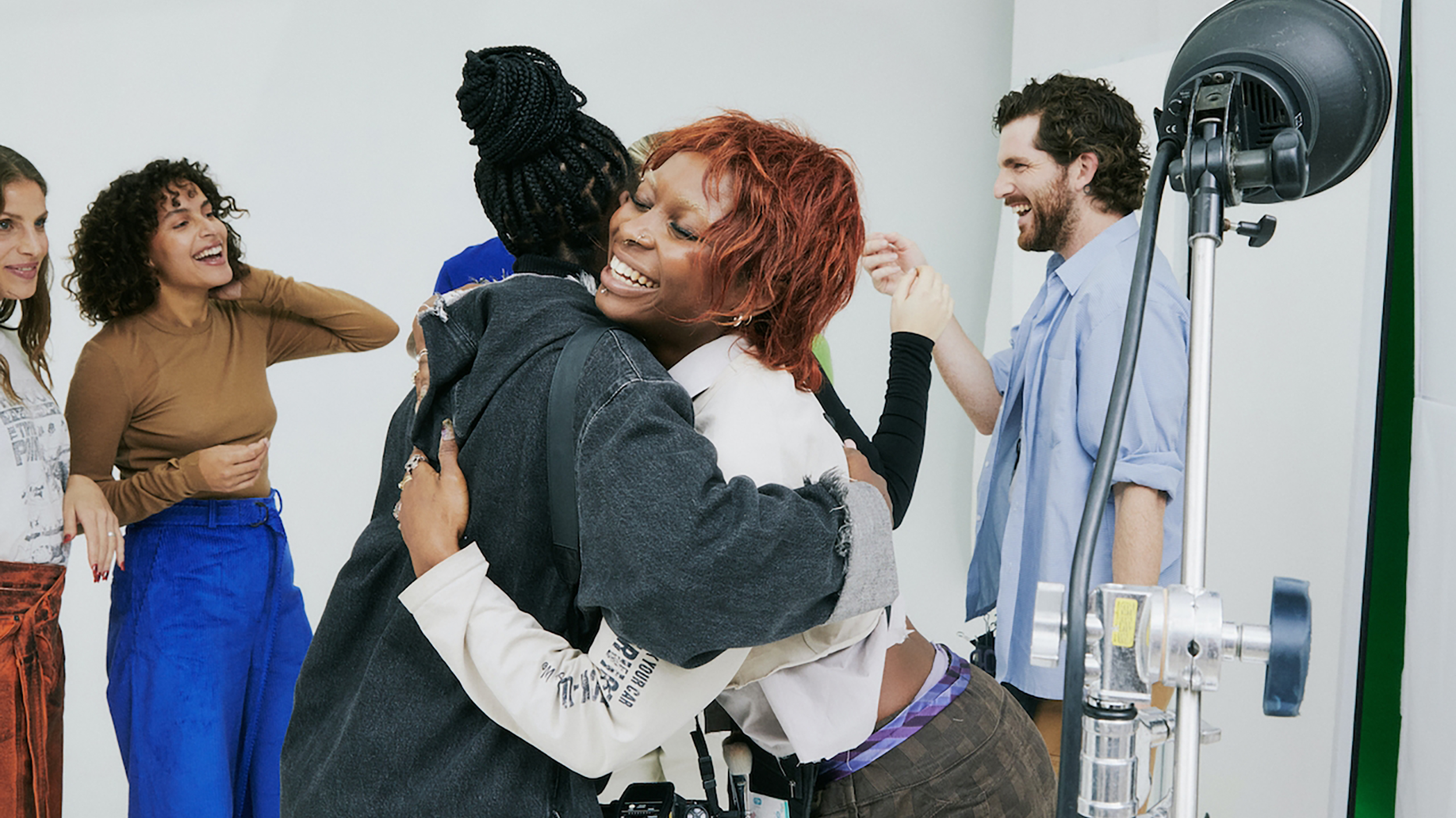 A group of people hugging in front of a secret camera.