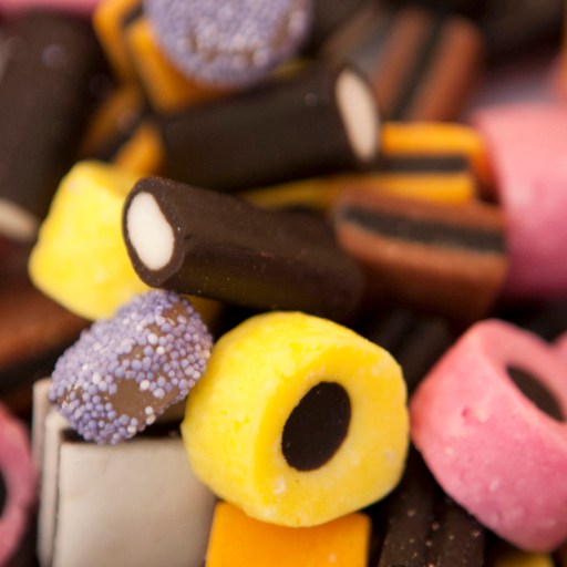 A close up of a pile of different colored candies, including one or two varieties infused with ammonium chloride.