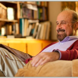 A man sitting in a chair with a book on his lap.