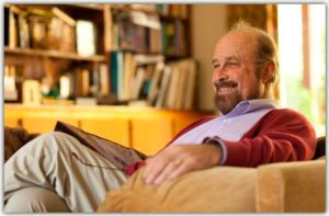 A man sitting in a chair with a book on his lap.
