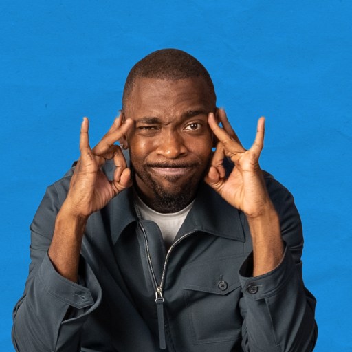 A black man with his hands on his head.