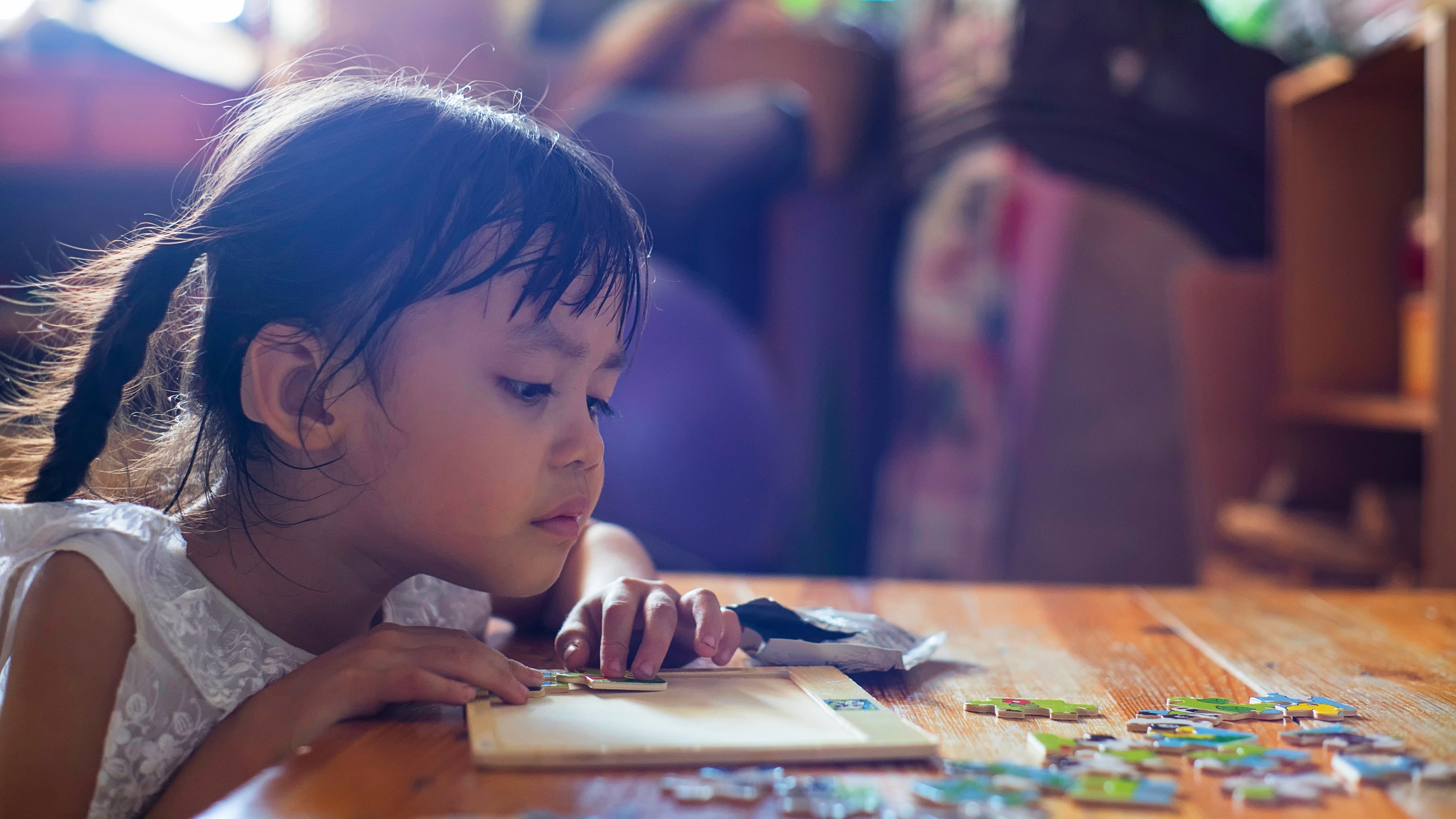 A child happily engaged in solving a large puzzle.