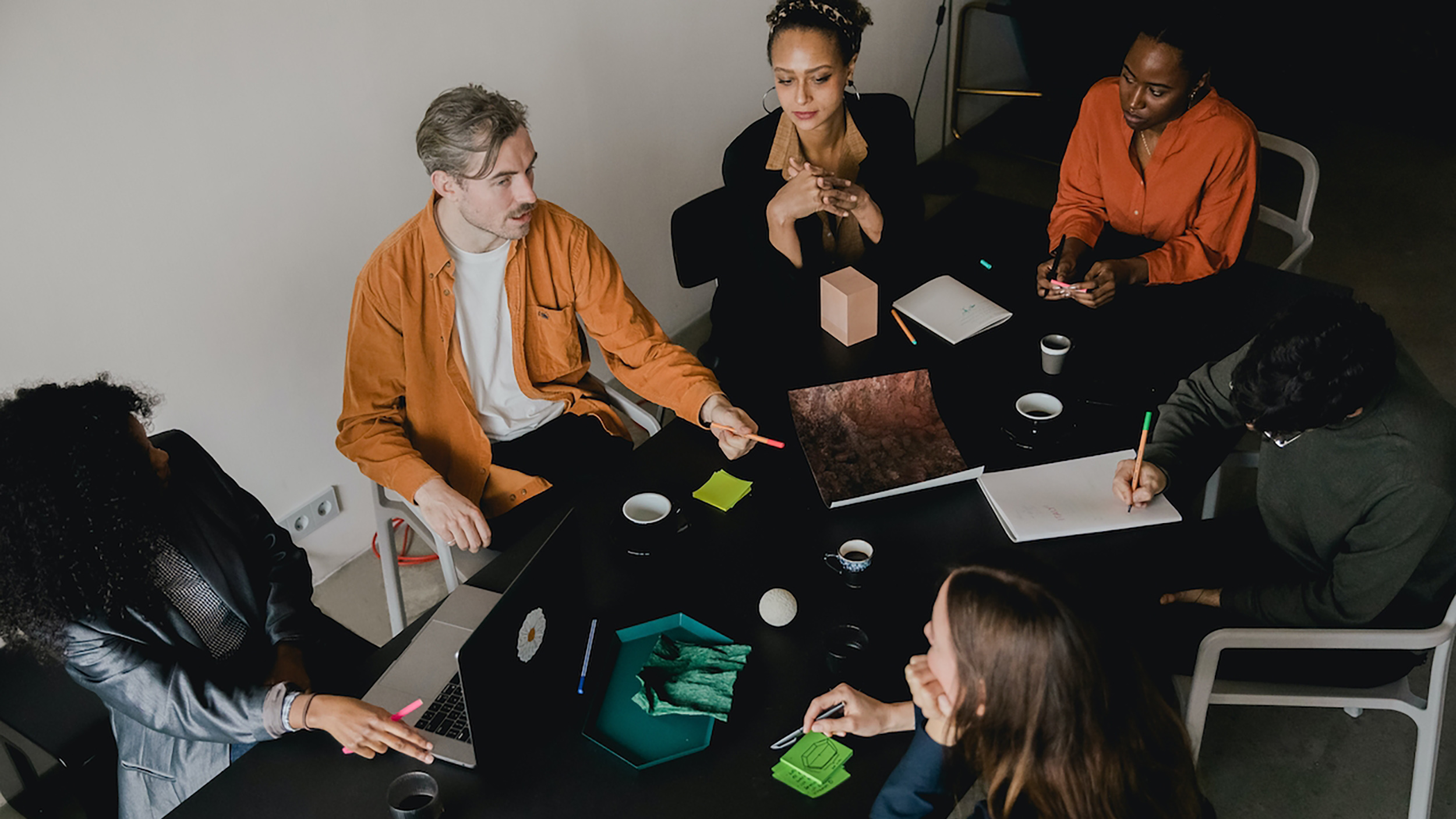 A group of people sitting around a table in a conference room, strategizing on how to retain talent.