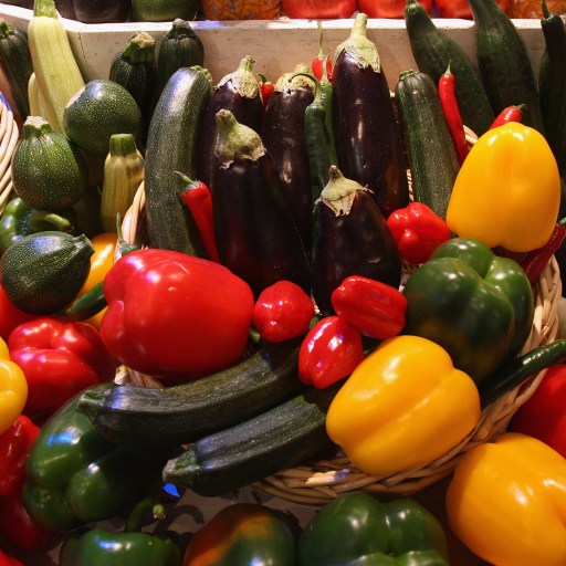 The baskets are filled with different kinds of vegetables.