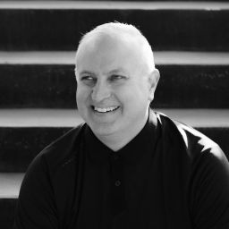 A black and white photo of a man smiling.