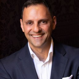 A man in a suit smiling for the camera.