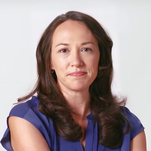 A woman in a blue shirt with her arms crossed.