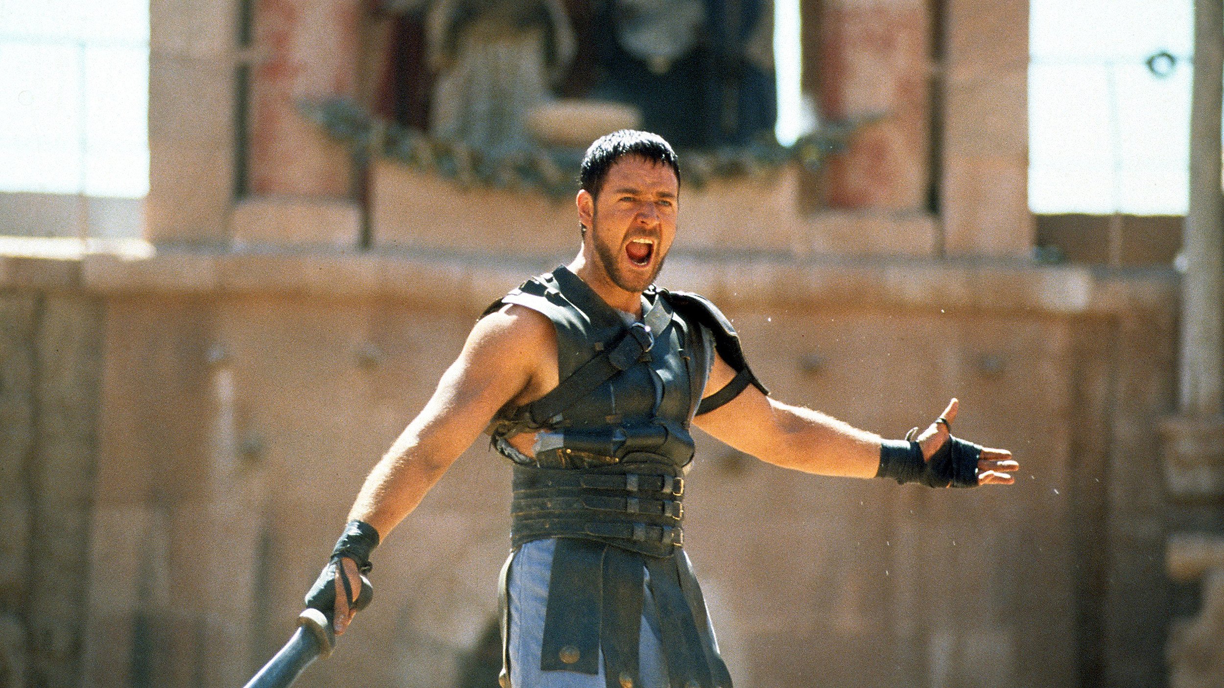 A gladiator brandishing a sword amidst a crowd.