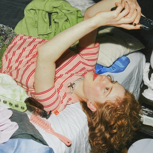 A woman utilizing her brain's executive function while laying on a bed surrounded by clothes.