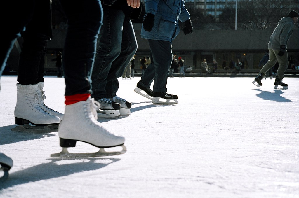 A group of people ice skating on the ice.