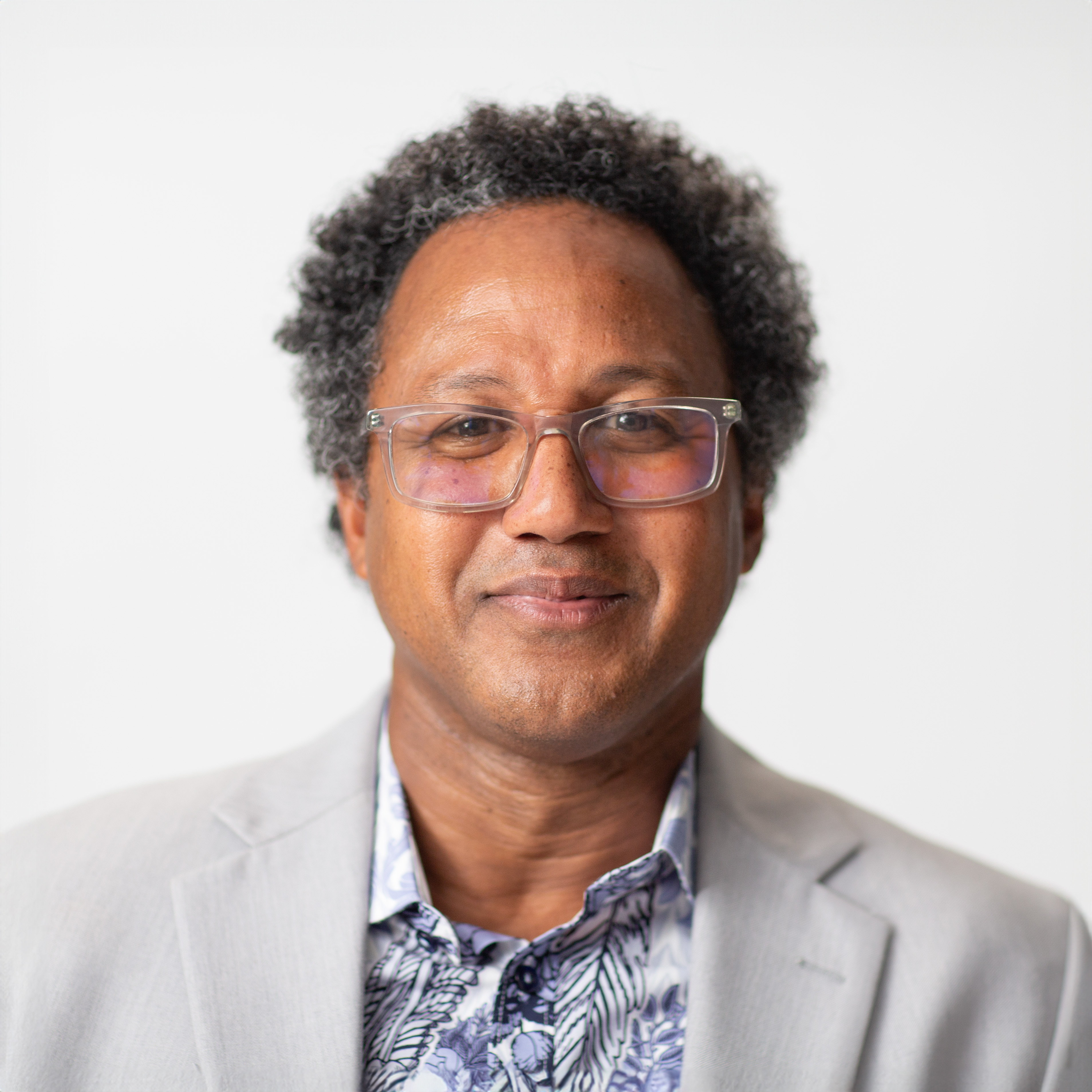 A man wearing glasses and a jacket.