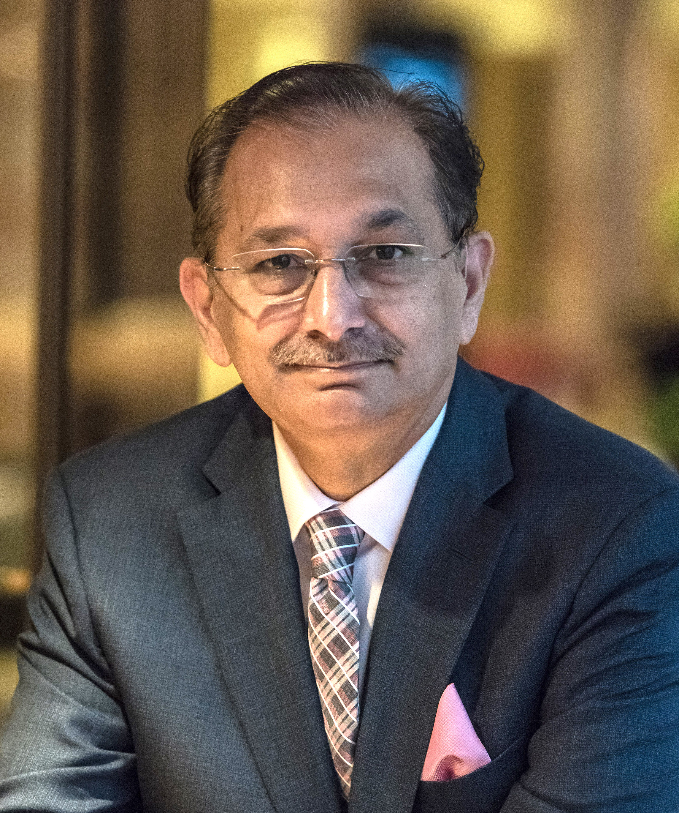 A man in a suit and tie sitting at a table.