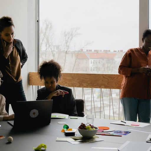A team of people standing around a table in an office.