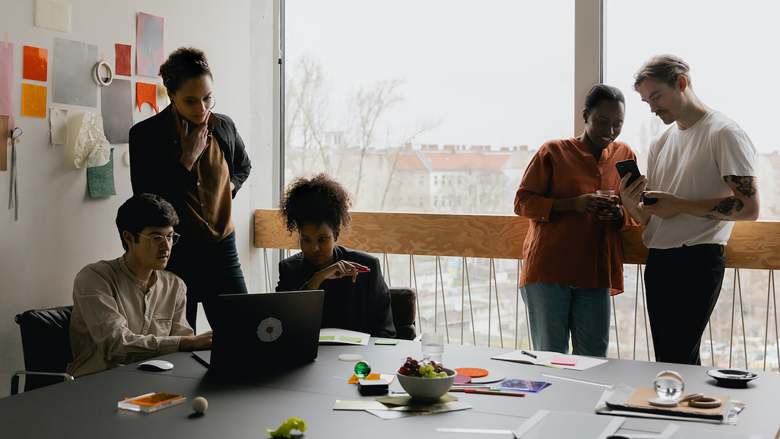 A team of people standing around a table in an office.
