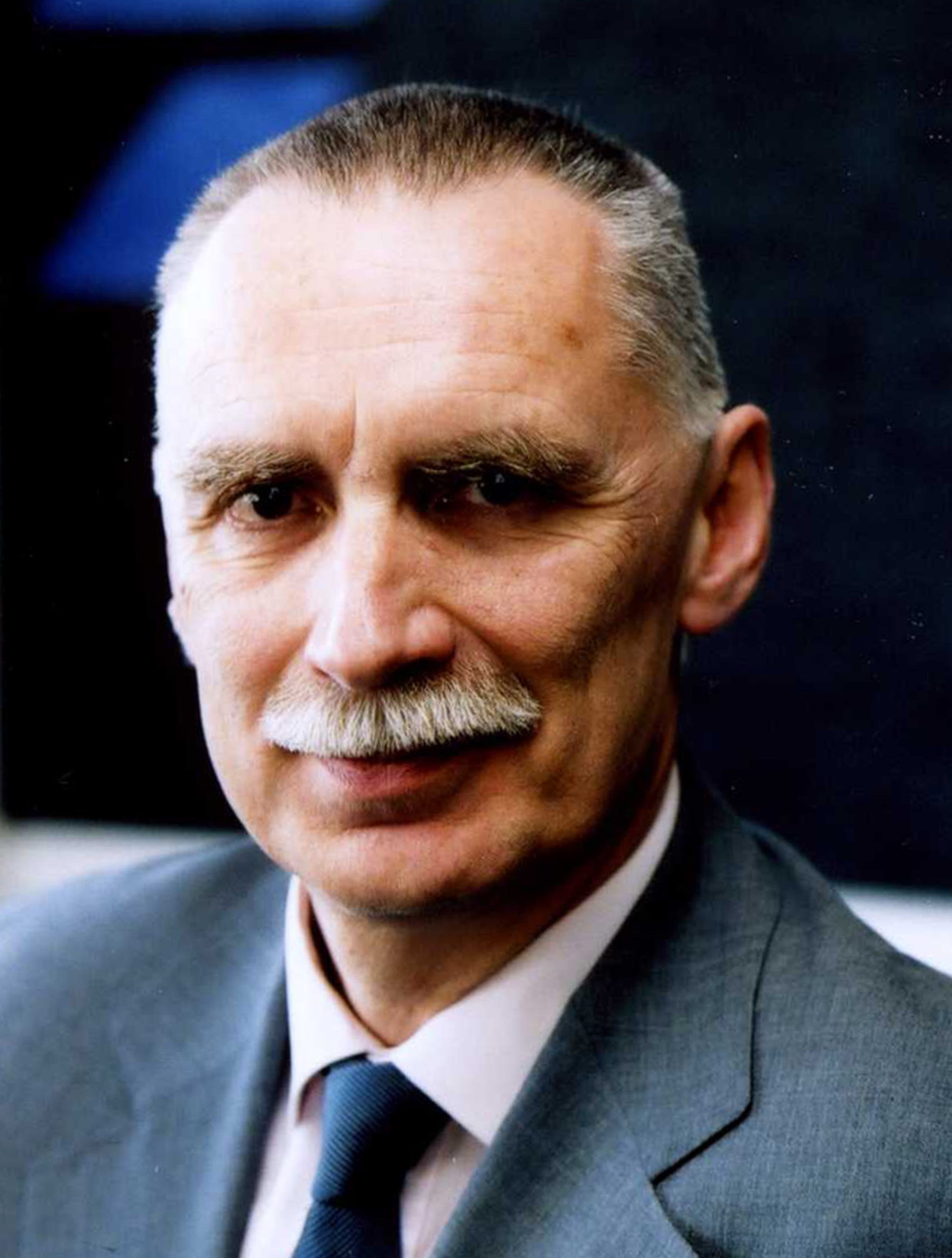 A man in a suit and tie with a mustache.