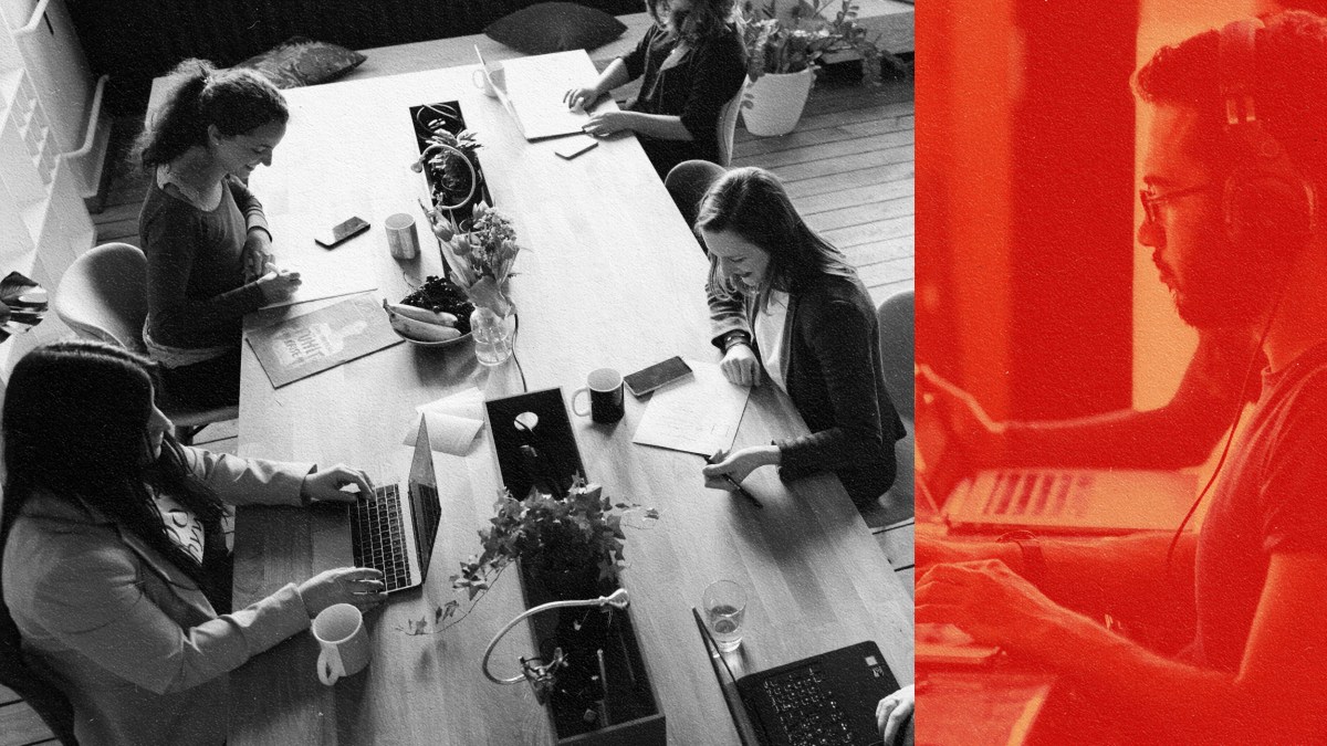 A group of people sitting at a table in a brave space, working on their laptops.