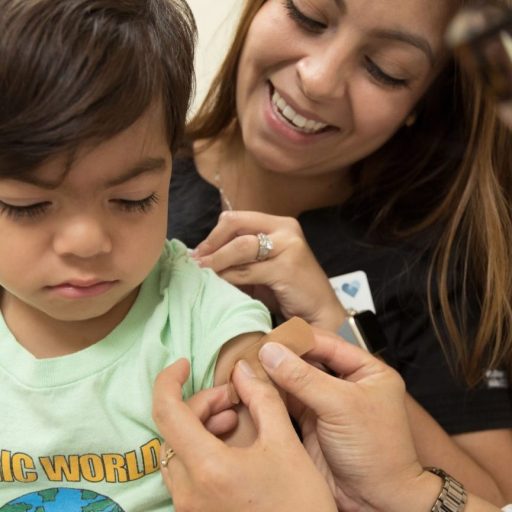 A young boy is getting an RSV injection from a doctor.