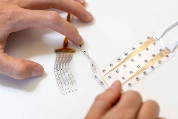 A person is holding a piece of plastic on a table.