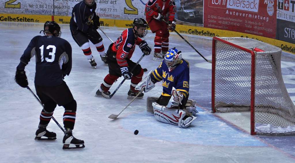 A group of men playing ice hockey on an ice rink.