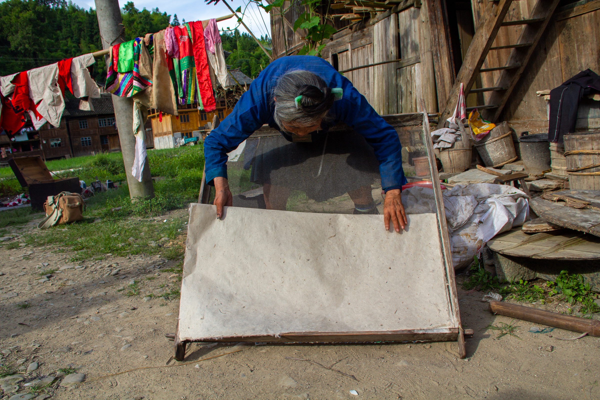 A woman inspecting a folded piece of paper with a curious expression.