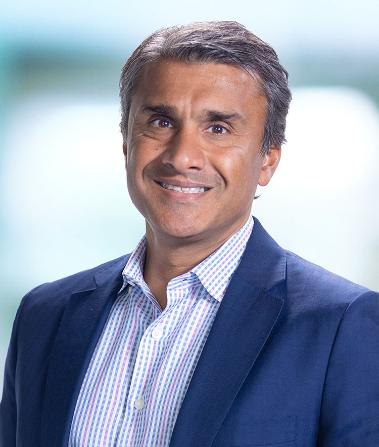 A man in a blue suit smiling for the camera.