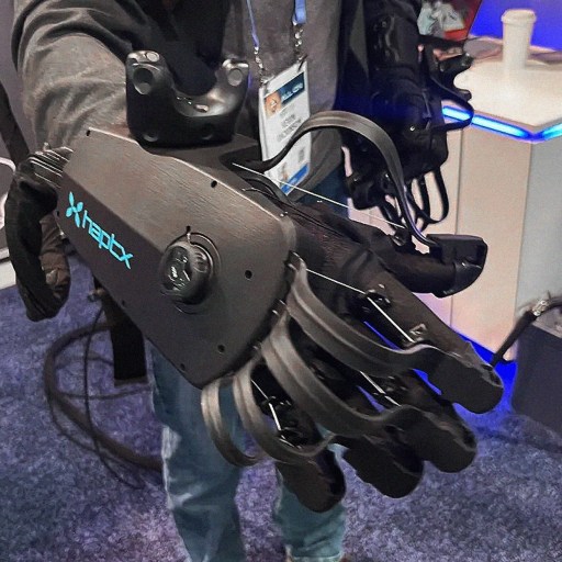 A person holding a robotic glove at a trade show.