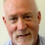 A man with a white beard and blue shirt.