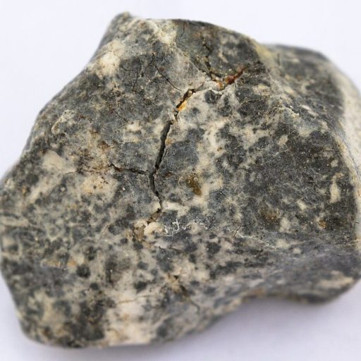 A small piece of rock from Germany on a white surface.