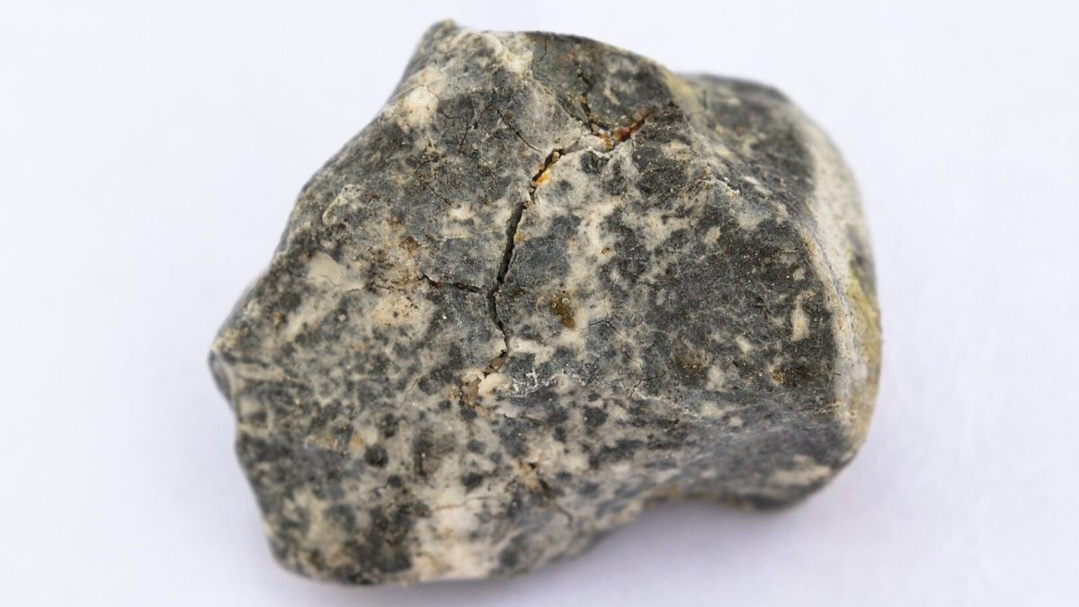 A small piece of rock from Germany on a white surface.