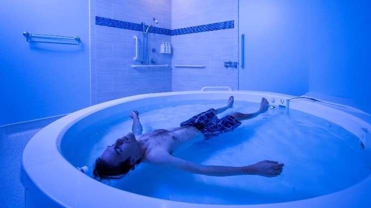 A man floating in a hot tub.