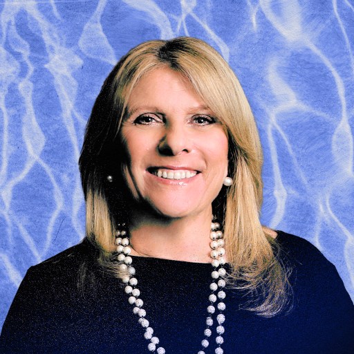 A badass CEO smiling in front of a blue background.