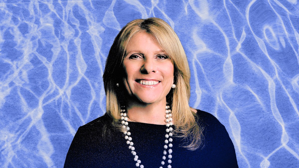 A badass CEO smiling in front of a blue background.