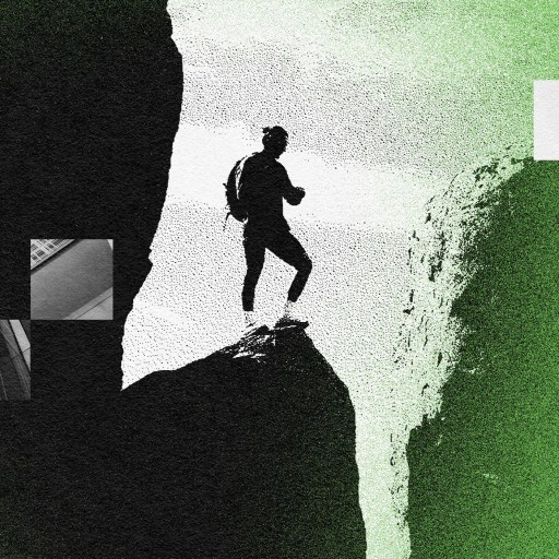 A man is fearlessly standing on top of a cliff.