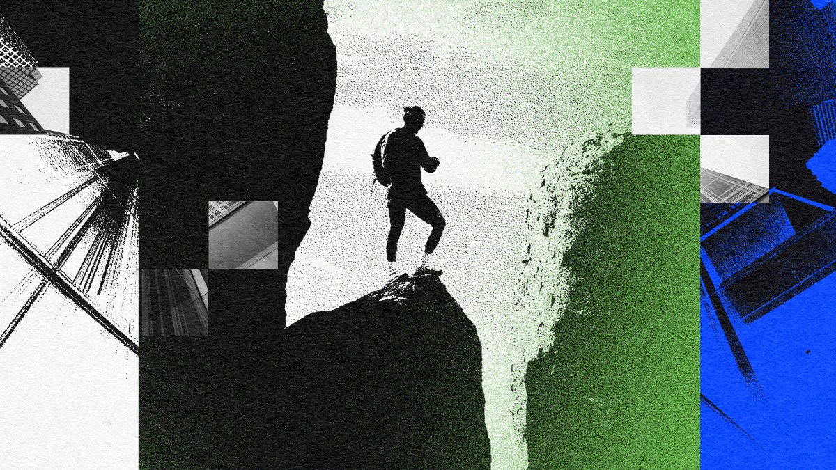 A man is fearlessly standing on top of a cliff.