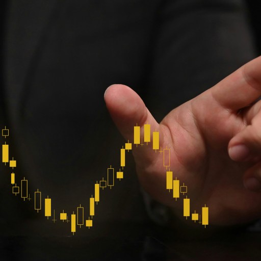 A businessman's hand is pointing at a stock chart, showing intentional growth.