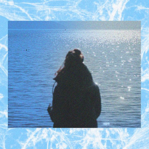 A photo capturing the memory of a woman standing in front of a body of water.