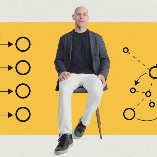 Bald man in casual attire sitting on a stool with a strategic diagram background in yellow.