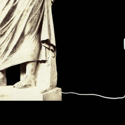 A marble statue with feet and draped clothing stands next to a wall outlet, connected by a white power cord against a black background.