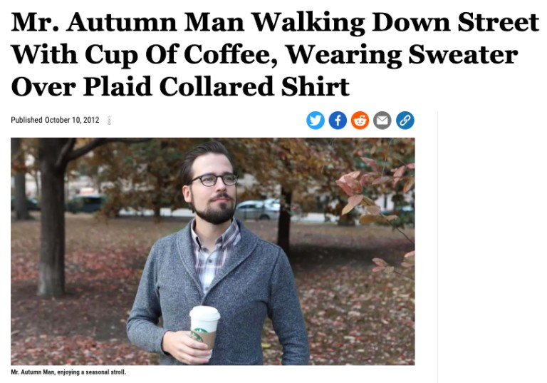 A man walks down the street holding a cup of coffee, wearing a sweater over a plaid collared shirt. The headline reads, "Mr. Autumn Man Walking Down Street With Cup Of Coffee, Wearing Sweater Over Plaid Collared Shirt.