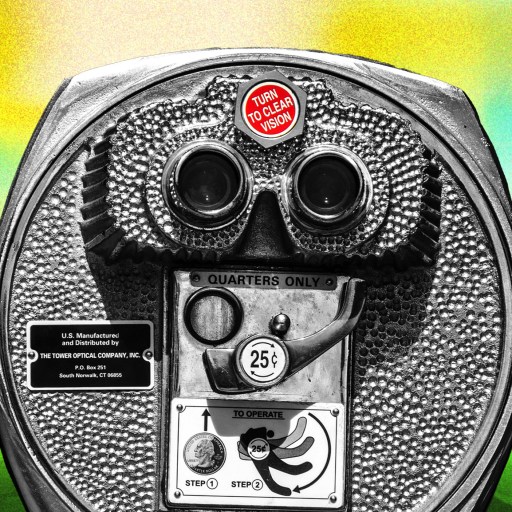 Close-up of a vintage coin-operated binocular viewer with a "Turn to Clear Vision" label, set against a colorful, blurred background.