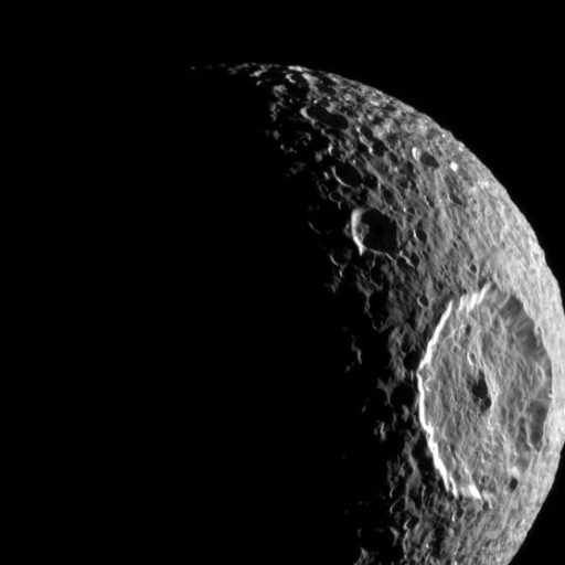 Image of Mimas, one of Saturn's moons, partially illuminated. The large Herschel crater is prominently visible on the right side of the moon's surface.