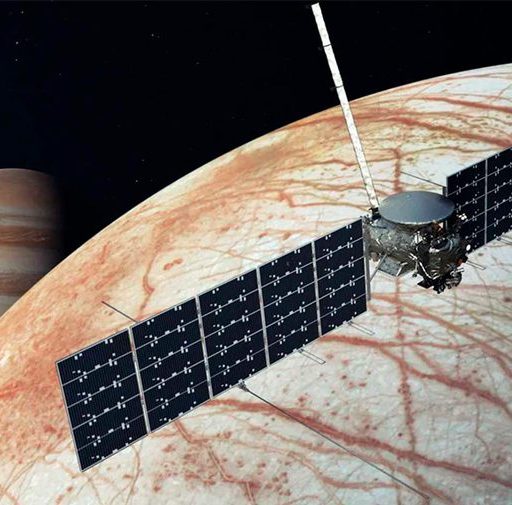 Spacecraft with solar panels orbits Europa, Jupiter's icy moon, with Jupiter visible in the background.