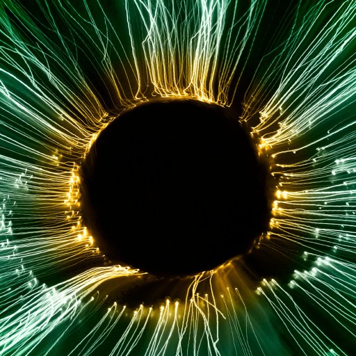Abstract image of a dark central circle surrounded by radial green and yellow light streaks resembling an eye or vortex.